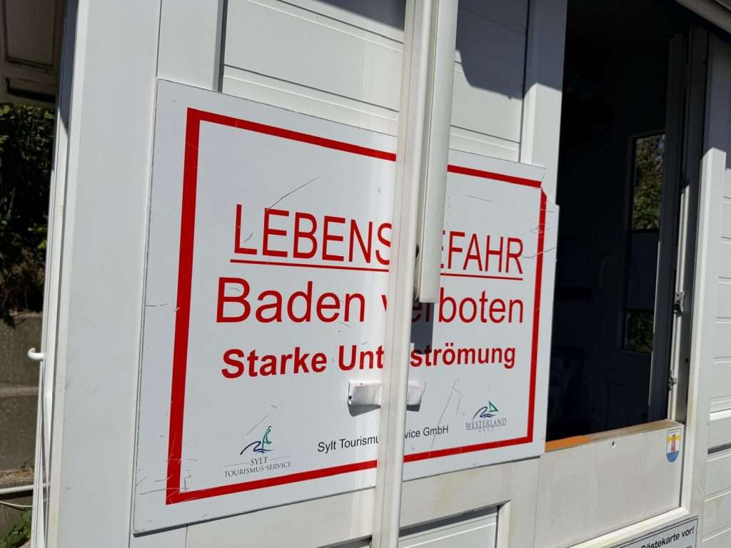 Warnschild „Lebensgefahr wegen Unterströmung" am Übergang zum Brandenburger Strand in Westerland auf Sylt Titel: Warnung vor Unterströmung am Brandenburger Strand, Westerland