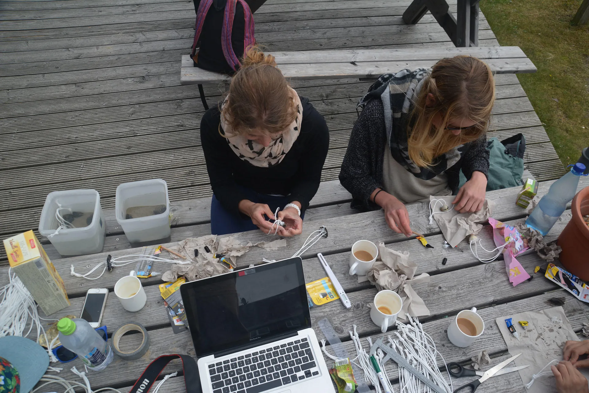 Zwei Studentinnen werten Muschelproben an einem Holztisch aus